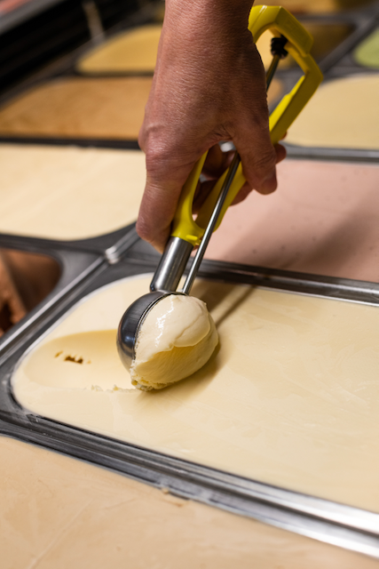 Hand using an ice cream scoop to scoop a serve of Tasmanian Honey Ice Cream
