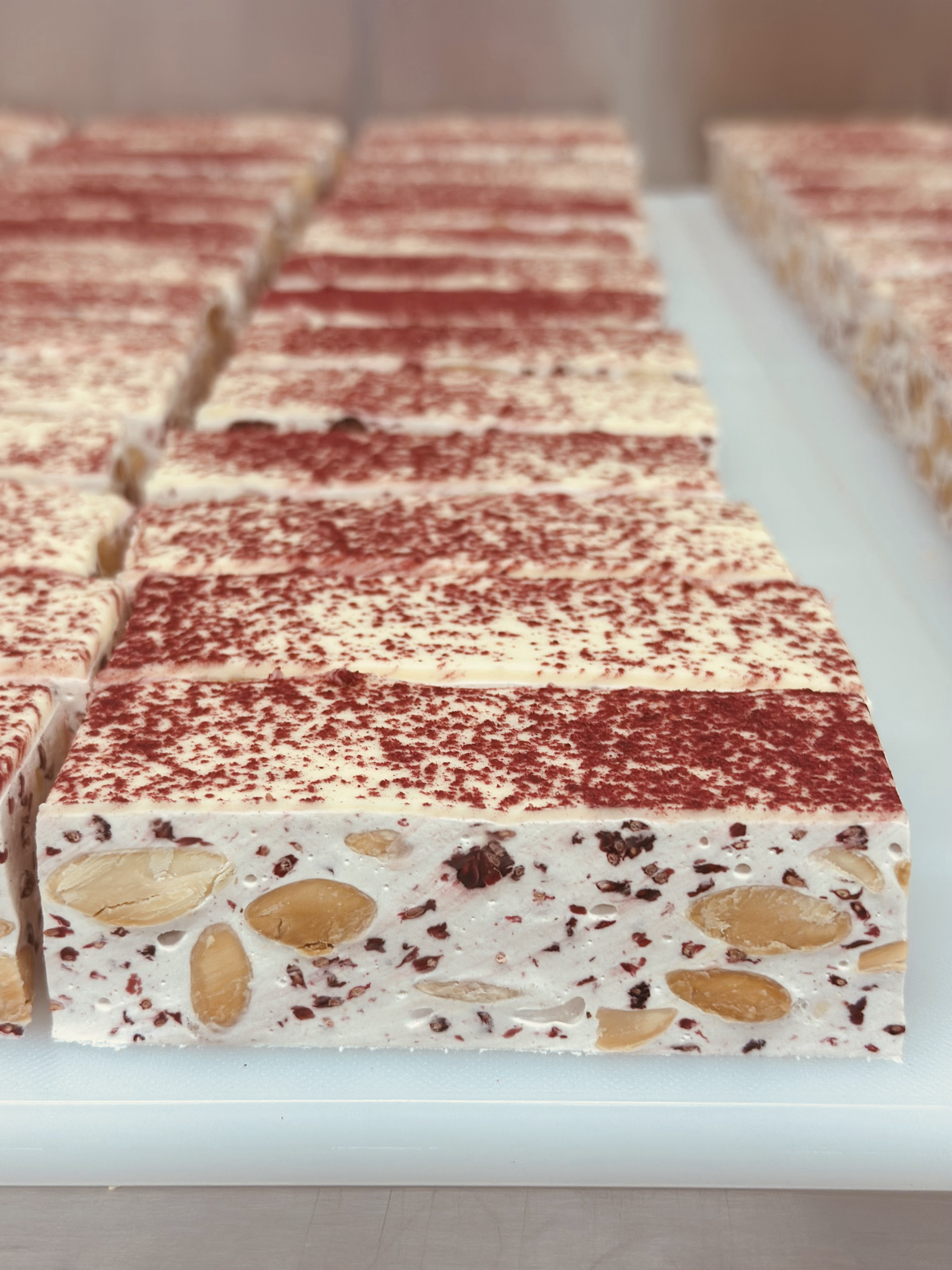 Bars of Raspberry Honey Nougat on a kitchen bench.